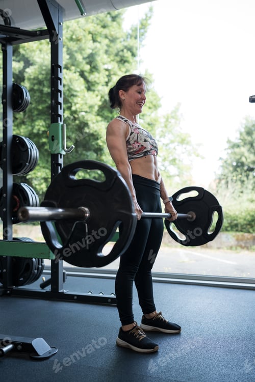 Preview: Strong woman lifting weights showing resilience and recovery