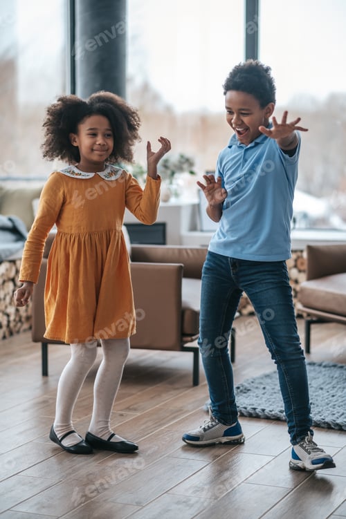 Preview: Smiling Children Playing Together Indoors With Hand Gestures