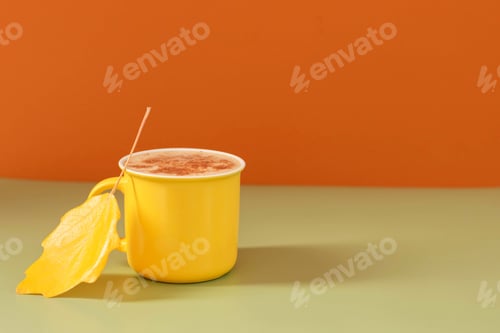 Preview: Autumn still life, yellow mug with hot drink tea coffee on a bright background with an autumn leaf