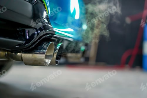 Preview: Close-up of the exhaust pipe emitting smoke from a chameleon-colored luxury car