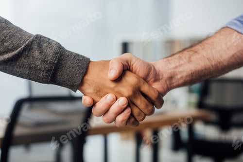 Preview: Cropped view of african american businessman shaking hands with colleague in office