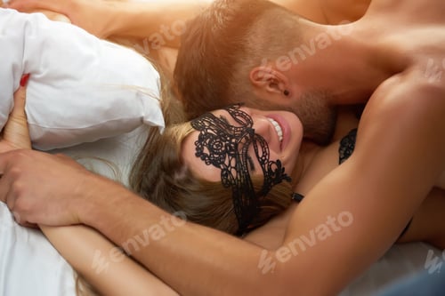 Preview: Happily smiling woman face in lace mask and kissing man, close-up.