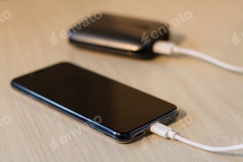Preview: Charging your smartphone from a portable charger, close-up.