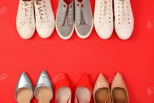 Preview: Flat lay composition with different bright shoes on red background. Space for text