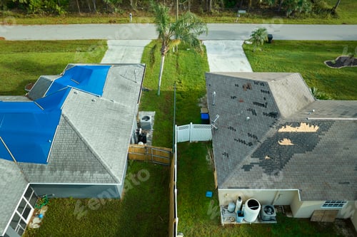 Preview: Aerial view of damaged in hurricane Ian house roof covered with blue protective tarp