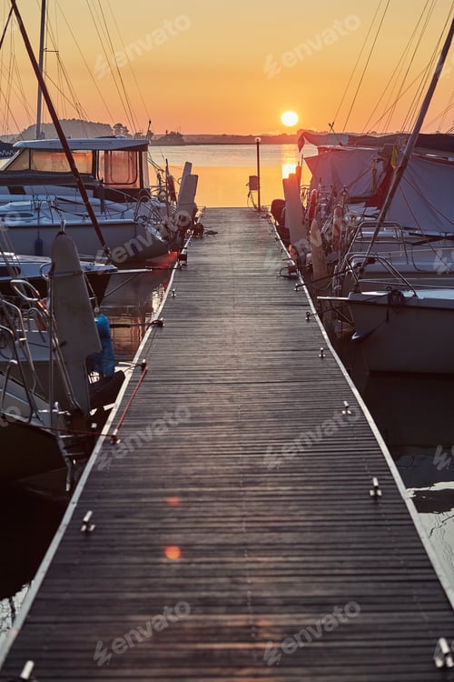 Preview: Yachts and boats moored in a harbour at sunrise. Candid people, real moments, authentic situations