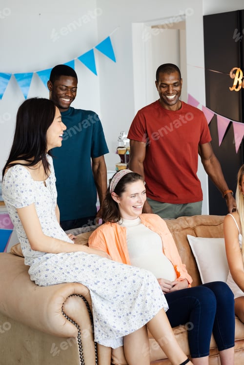 Preview: Friends celebrating together at home, smiling and enjoying joyful moments on couch