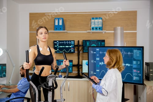 Preview: Female patient giving physical activity tests in the lab while a doctor supervises her