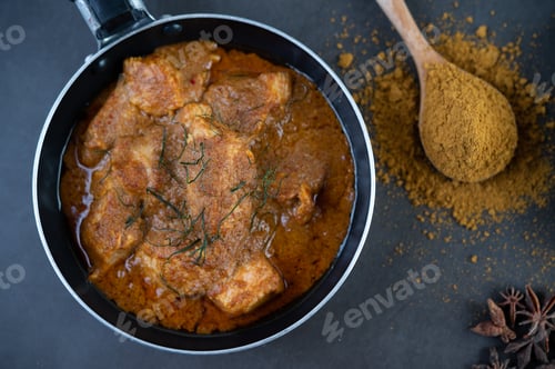 Preview: Massaman curry in a frying pan with spices on the cement floor