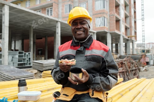 Preview: Happy mature black man with sandwich and cup of hot tea looking at camera