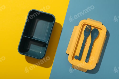 Preview: A blue lunchbox with a yellow lid and blue forks
