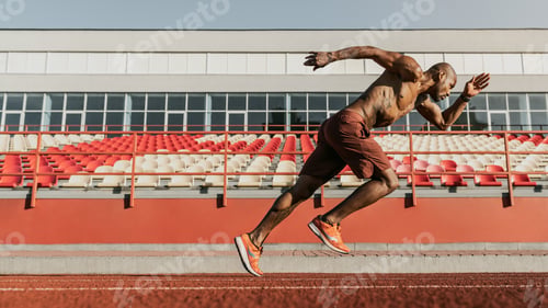Preview: Side view shot of male sprinter running on the sport track. Athlete runner doing workout