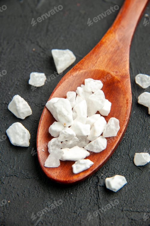 Preview: bottom view sea salt on wooden spoon on black background