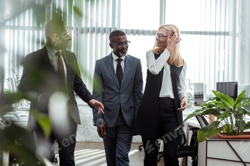 Preview: selective focus of happy multicultural partners smiling in office