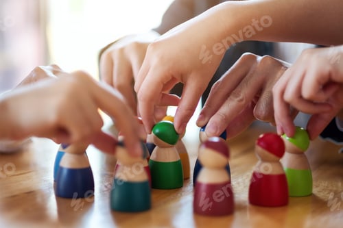 Preview: People choosing and picking up wooden figure from a group on the table
