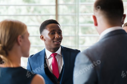 Preview: Business professionals engage in conversation during a networking event in a modern office