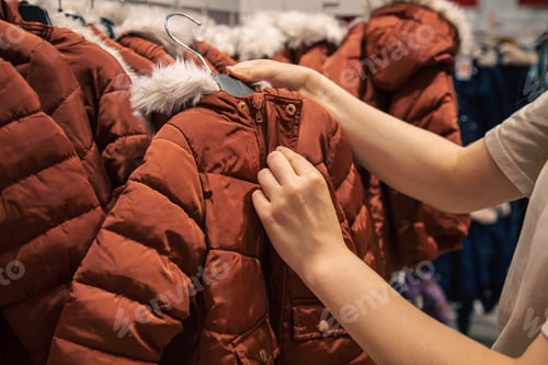 Preview: Children's jackets on hangers in a clothing store.
