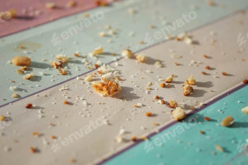 Preview: Crumbs scattered on a colorful table surface