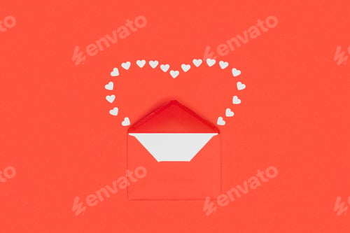 Preview: top view of red envelope with white card and small hearts isolated on red