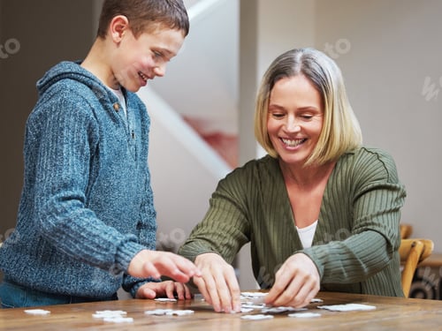 Preview: Dont worry Ill help you. Shot of a mother completing a puzzle with her son.