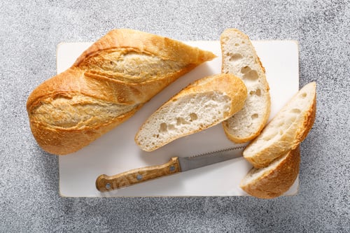 Preview: Bread, baguette sliced on a board, top view