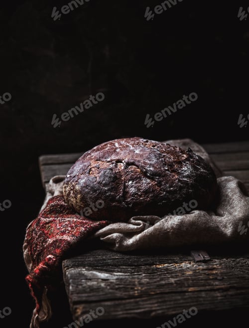 Preview: Bread on a rural on a black background. homemade baking