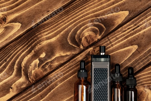 Preview: Vape and vape juice bottles on brown wooden background