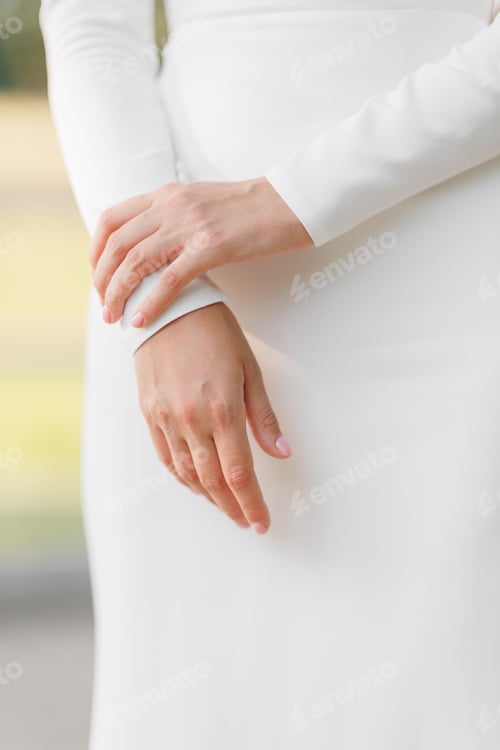 Preview: Unrecognisable woman in elegant white wedding slim dress outdoors. Cropped photo of woman hands