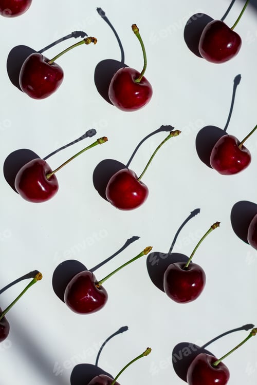 Preview: Layout of red cherry berries with contrasting shadows.