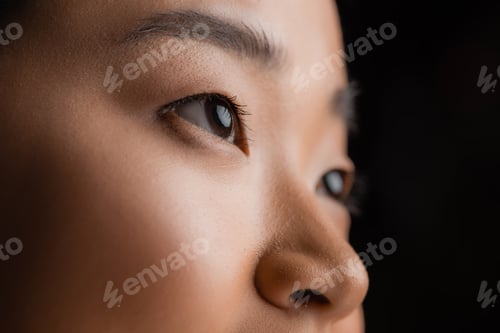 Preview: partial view of asian woman with perfect skin and natural makeup isolated on black