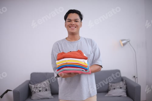 Preview: Man Holding Stack of Colorful Folded Clothing
