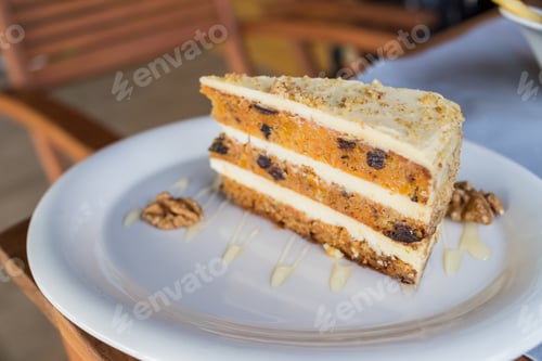 Preview: Close-up of walnut carrot cake on white plate.Raw vegan and gluten-free Carrot cake with nuts