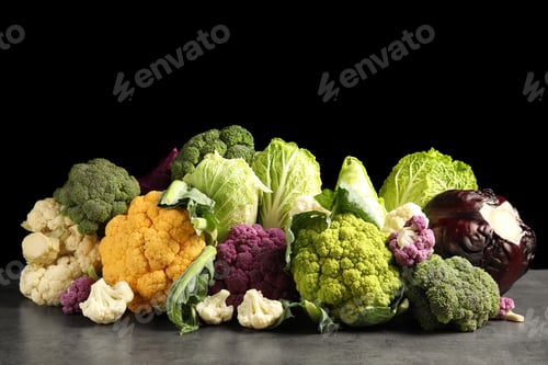 Preview: Different fresh cabbages on table against black background. Healthy food