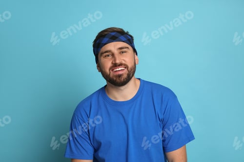 Preview: Fashionable young man wearing stylish bandana on light blue background