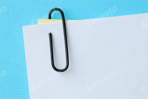 Preview: Paper notes with clip on light blue background, top view. Space for text