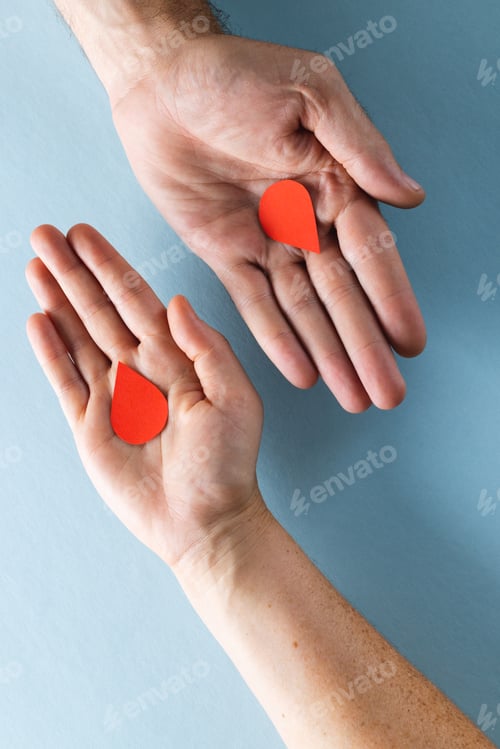 Preview: Hands of caucasian woman and man holding blood drops, on blue background