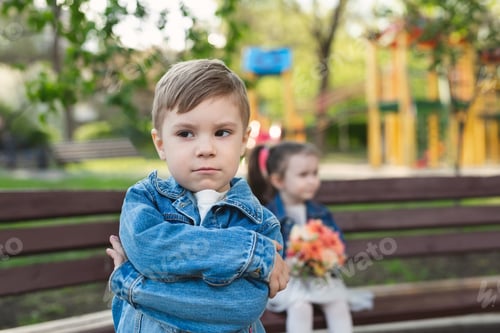 Preview: Date of a little boy and a girl in the park with a bouquet of flowers. The boy was offended