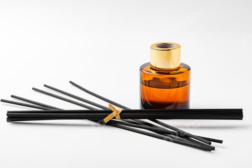 Preview: A minimalist display of essential oil and black diffuser sticks on a clean white background