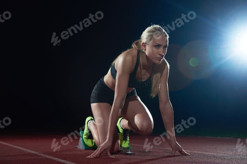 Preview: Woman Sprinter Leaving Starting Blocks On The Athletic Track. Side View. Exploding Start