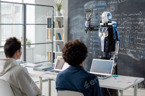 Preview: Two teenage students looking at robot demonstrating his abilities by blackboard