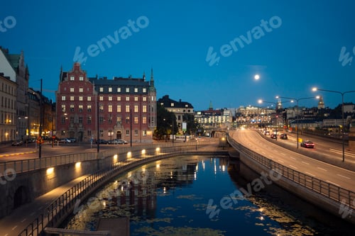 Preview: Twilight cityscape with historical buildings reflected in the calm waters of a canal