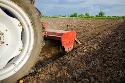 Preview: A tractor with a cutter unit is cultivating the field.