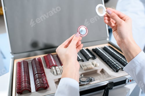 Preview: cropped view of ophthalmologist holding lenses for trial frame