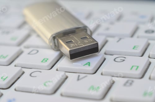Preview: USB Flash memory card on buttons of white modern keyboard. Media storage concept