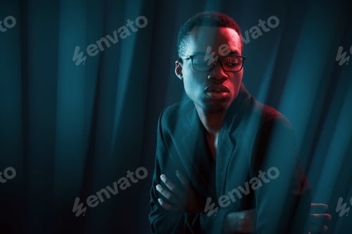 Preview: Interesting beams. Futuristic neon lighting. Young african american man in the studio