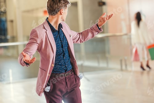 Preview: stylish young man with empty pockets turning back on girlfriend while she walking away at shopping