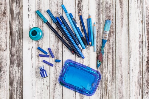 Preview: A burst of creativity on a wooden canvas with blue art supplies