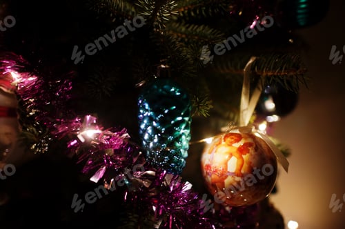 Preview: Christmas tree with shining garlands on evening home.