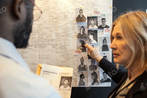 Preview: Blond confident female detective pointing at photo of suspect on board
