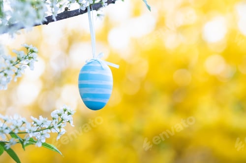 Preview: Children's Easter egg with decorations in the form of colored stripes against Prunus padus, bird